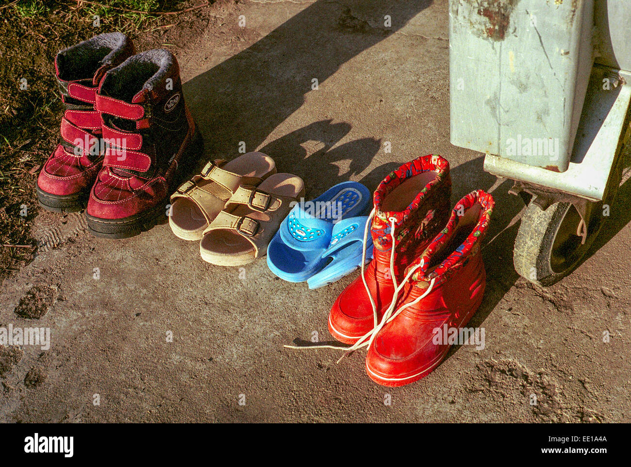 Abgenutzte Schuhe werden am Abfalleimer, am unteren Teil, verschwendet Stockfoto
