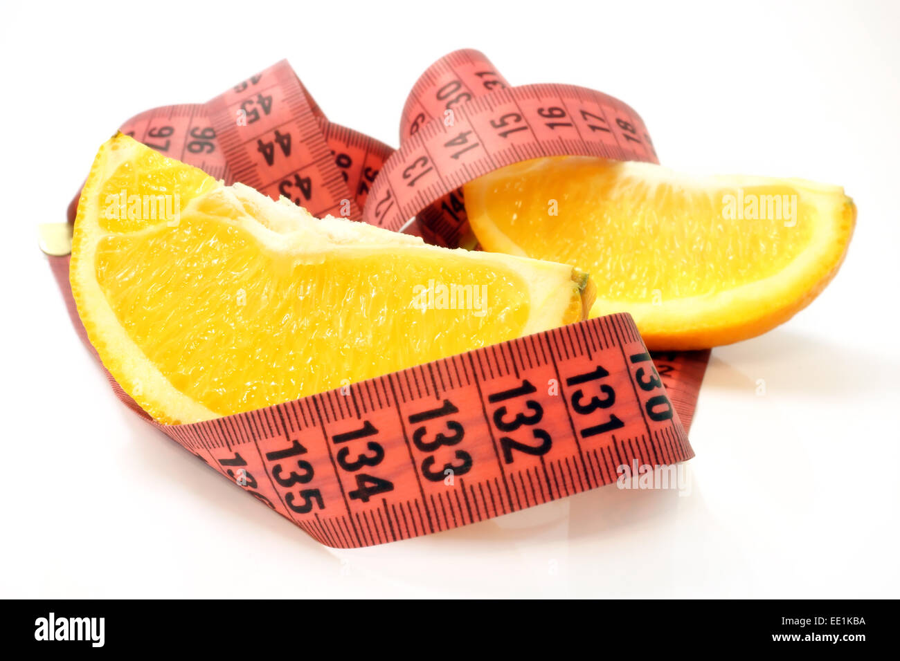 Orangenscheiben mit Maßband auf weißem Hintergrund. Obst-Diät-Konzept. Selektiven Fokus. Stockfoto