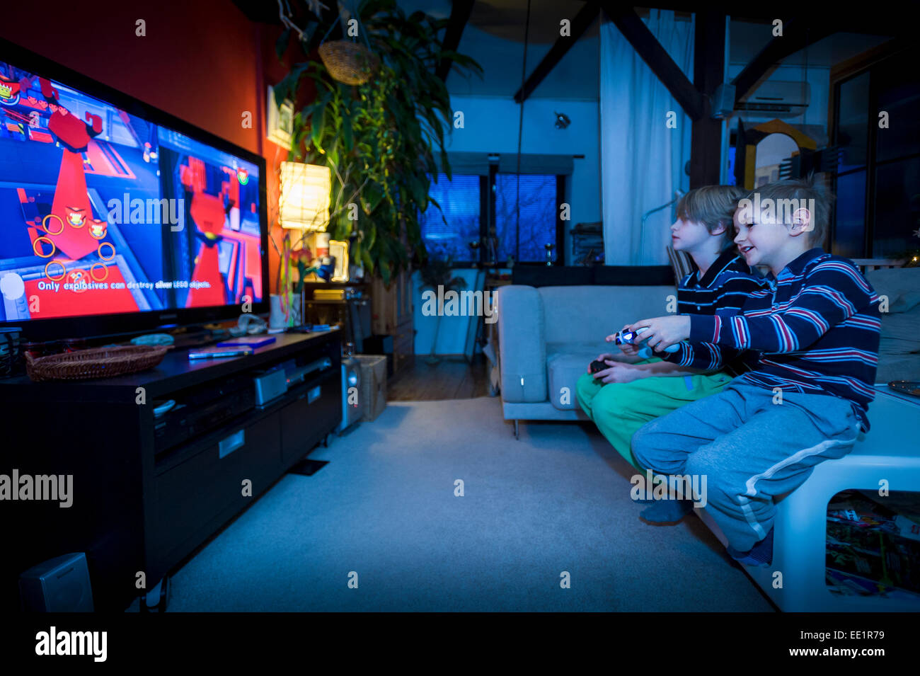 zwei junge Brüder sitzen vor TV und Videospiel Stockfoto