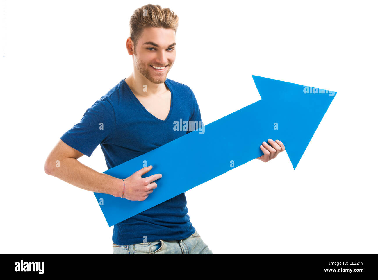 Gut aussehender junger Mann hält einen blauen Pfeil, isoliert auf weißem Hintergrund Stockfoto