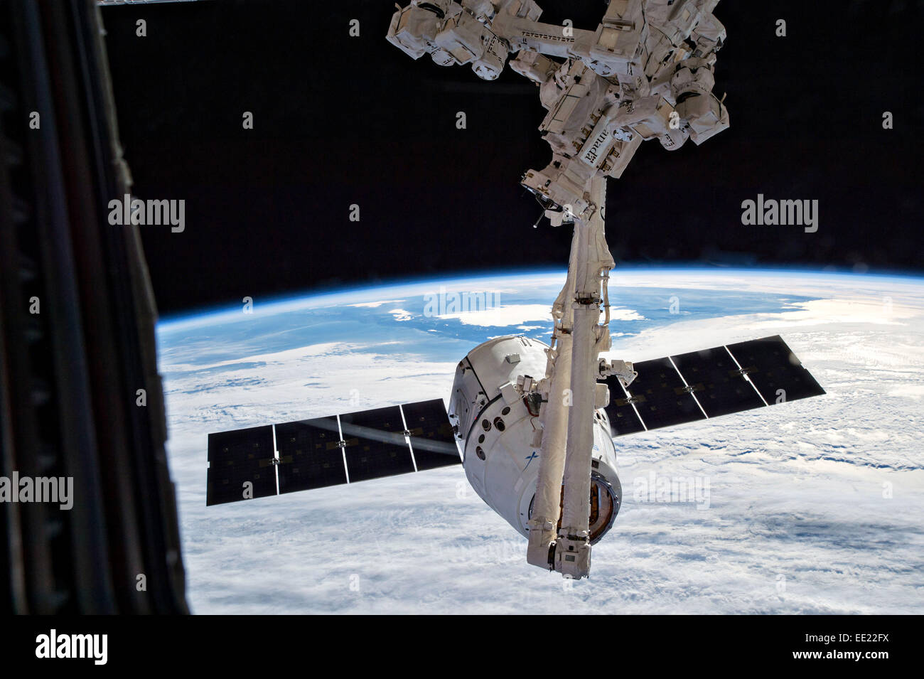 SpaceX Dragon kommerzielle Fracht Handwerk wird durch den Canadarm2-Roboterarm zum Andocken mit der internationalen Raumstation ISS 12. Januar 2015 in der Erdumlaufbahn abgerufen. Dragon verbringen die nächsten vier Wochen an der Harmonie-Knoten angehängt, die Expedition 42 Crew Zubehör, Hardware, Experimente, und Computer-Ausrüstung und Ausstattung entlädt. Stockfoto