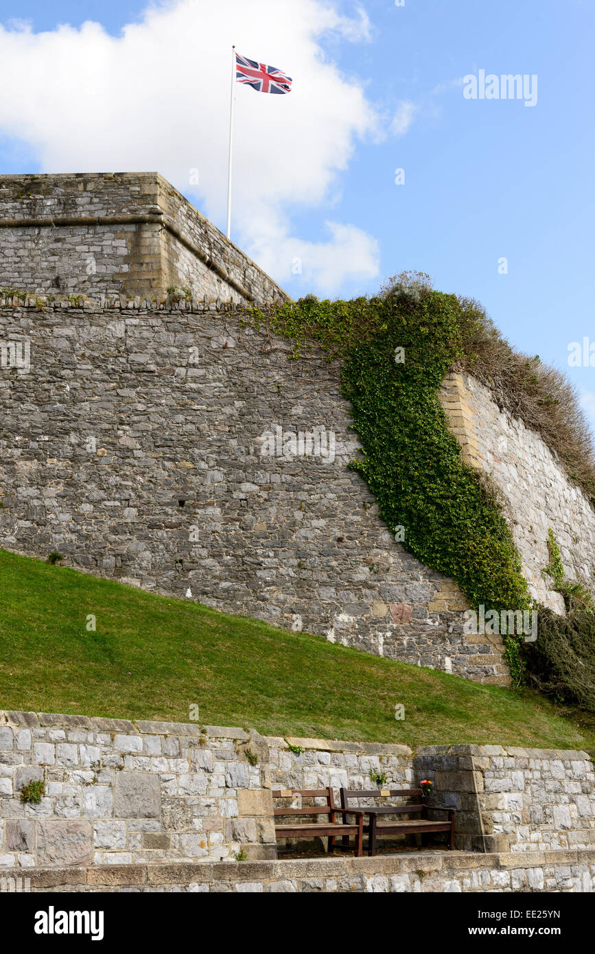 Blick auf die große Mauer, die den Bereich des Schlosses mit Holzbänken und einer wehenden Union Jack-Flagge umschließt Stockfoto