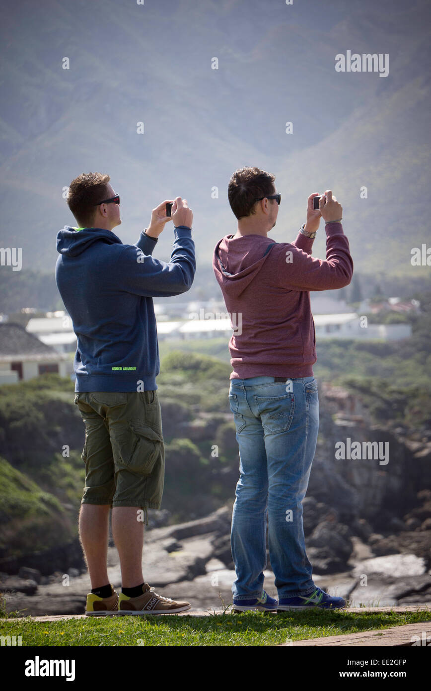 Zwei Männer fotografieren Southern Right Wale in Hermanus in der Western Cape, Südafrika.  Sie sind Kompaktkameras verwenden. Stockfoto