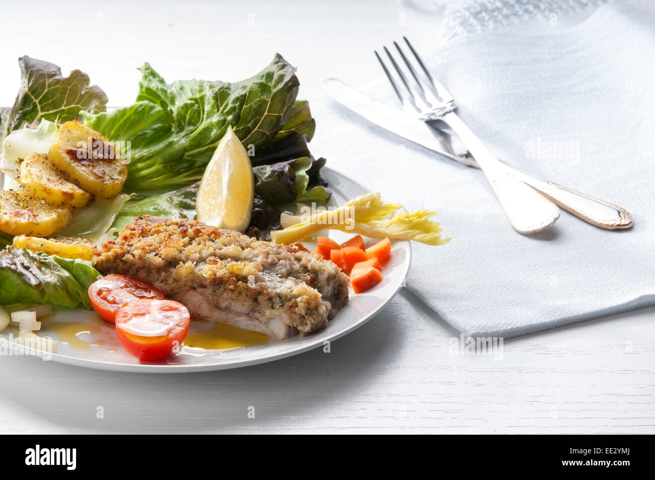 Kabeljaufilet paniert und gebacken mit Kartoffeln und Salat als Beilage Stockfoto