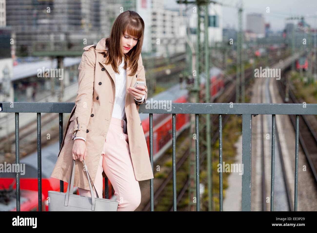Junge Frau mit Telefon im Freien, München, Bayern, Deutschland Stockfoto