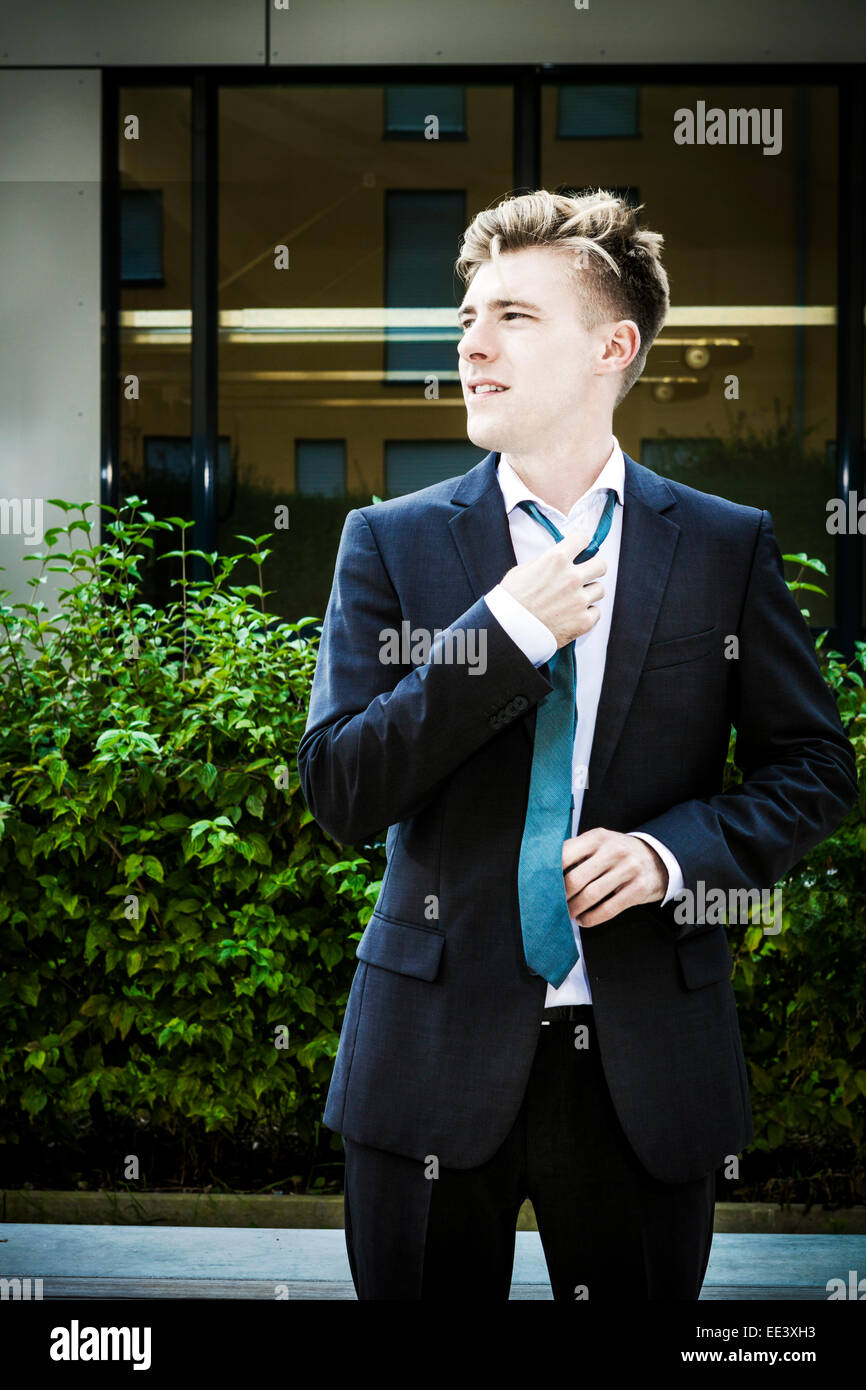 Junger Geschäftsmann Anpassung seine Krawatte, München, Bayern, Deutschland Stockfoto