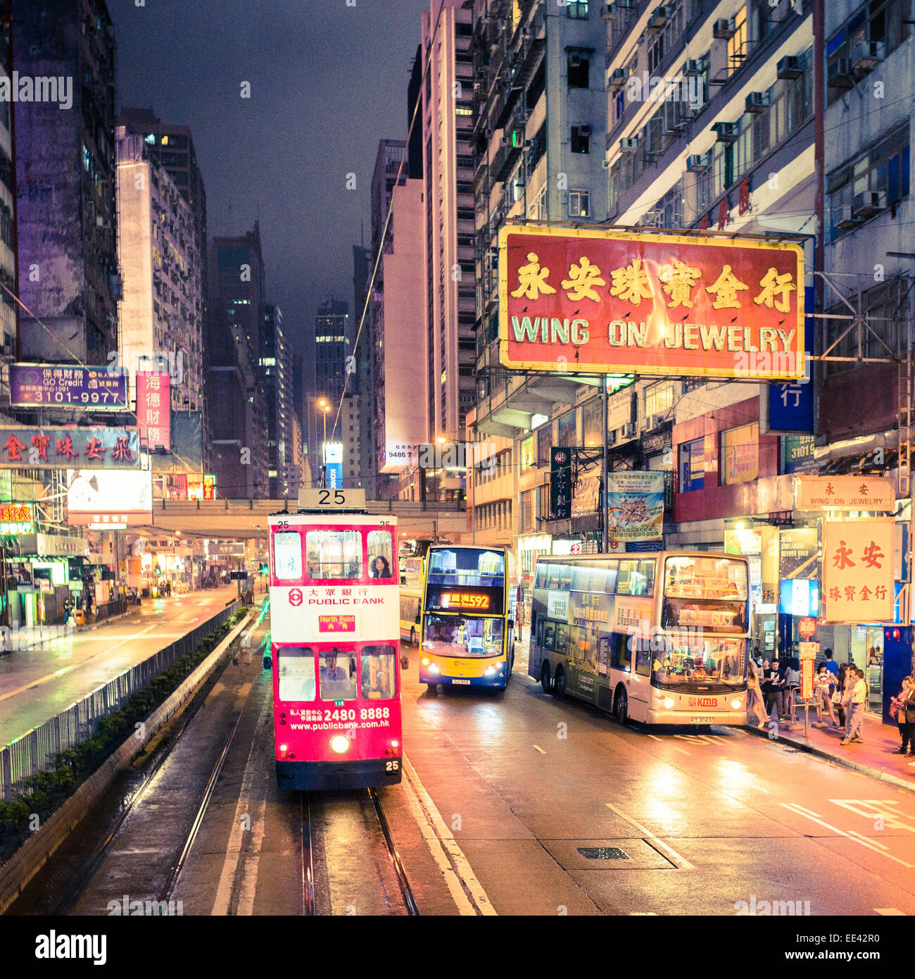 Hong Kong Straßenbahn unterwegs in der Nacht mit Stadtbild. Stockfoto