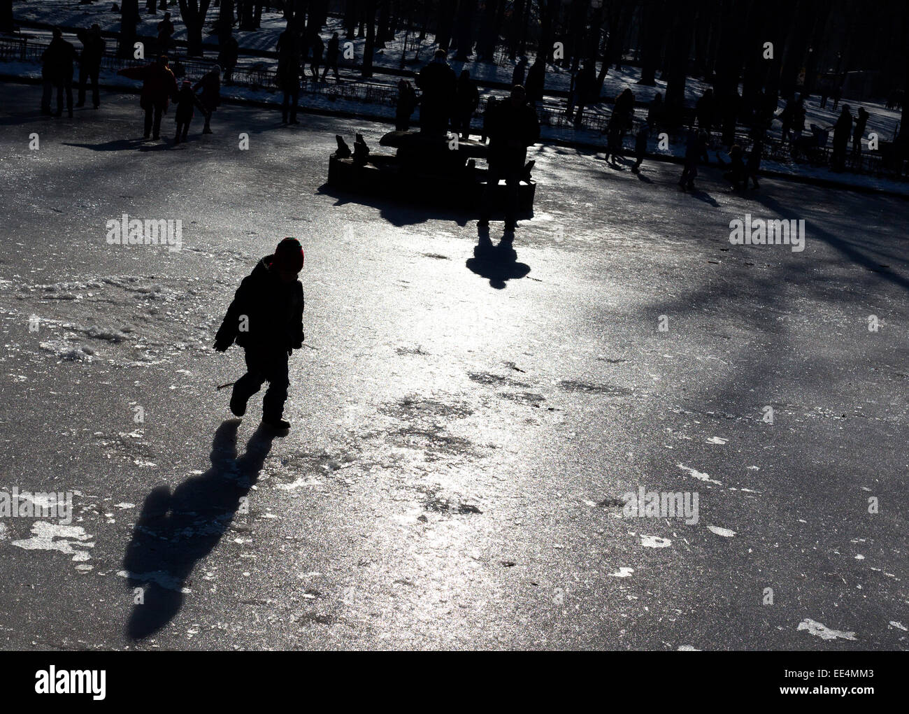 Kinder spielen auf der Oberfläche eines Brunnens gefroren. Stockfoto