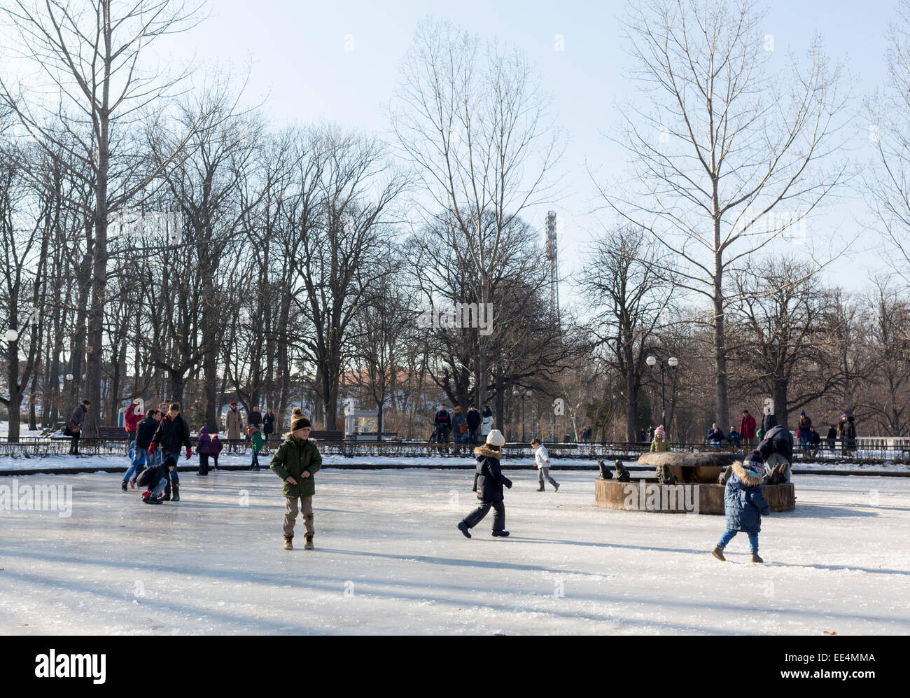 Sofia, Bulgarien - 11. Januar 2015: Kinder spielen sich auf der Oberfläche eines zugefrorenen Brunnens in einem Park in Sofia. Stockfoto