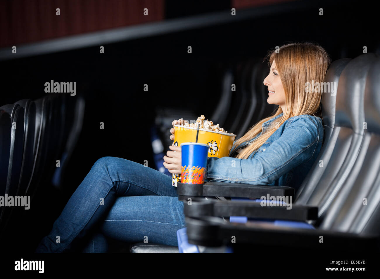 Frau mit Snacks während Films am Theater Stockfoto