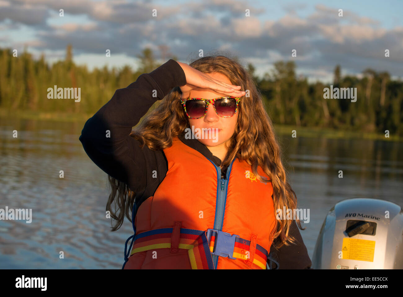 Mädchen, die Abschirmung Augen vor dem Sonnenlicht, Lake Of The Woods, Ontario, Kanada Stockfoto