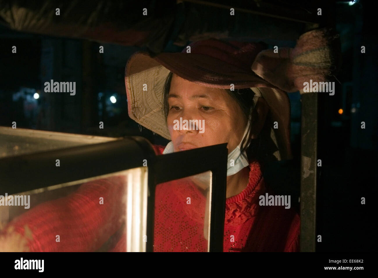 Straßenverkäufer Frau arbeitet in der Nacht auf einer Stadtstraße in Kampong Cham, Kambodscha. Stockfoto