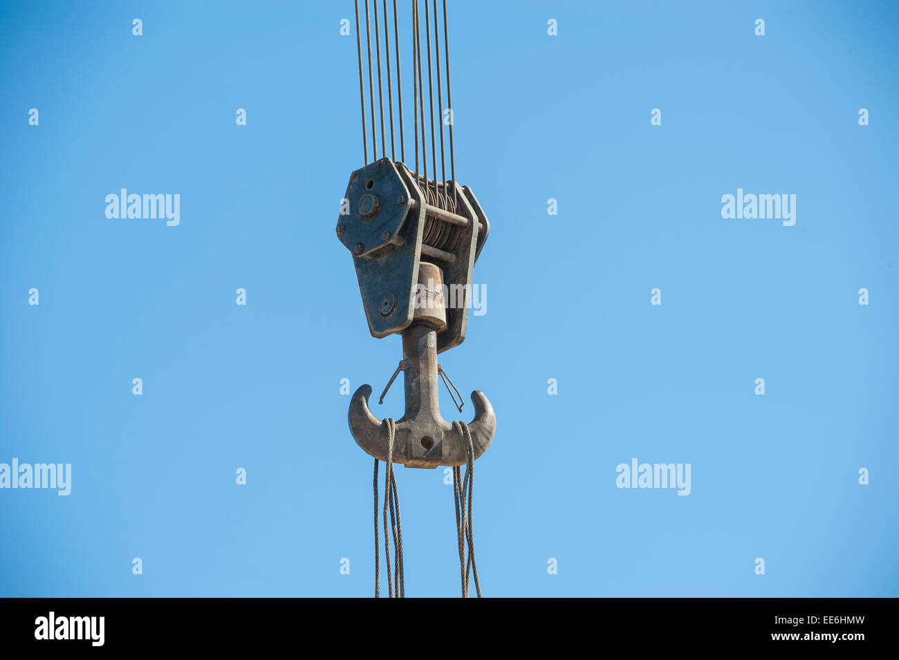 Großen Stahlhaken an Kabeln von schweren Industriekran Maschinen vor blauem Himmelshintergrund Stockfoto