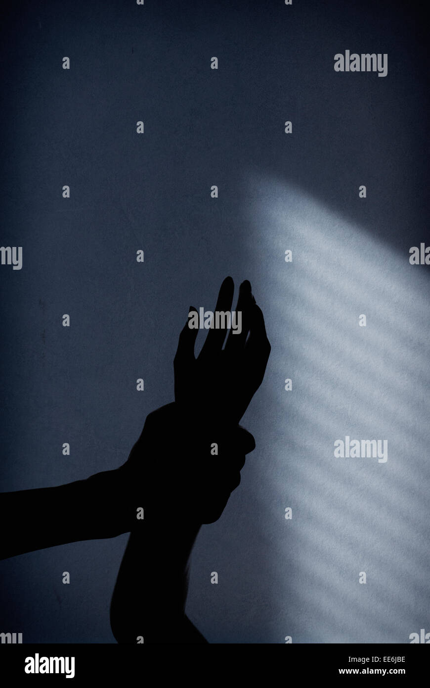 Schatten der Mann, der Arm der Frau im dunklen Raum hält. Konzeptbild von häuslicher Gewalt, Missbrauch und Kriminalität. Stockfoto