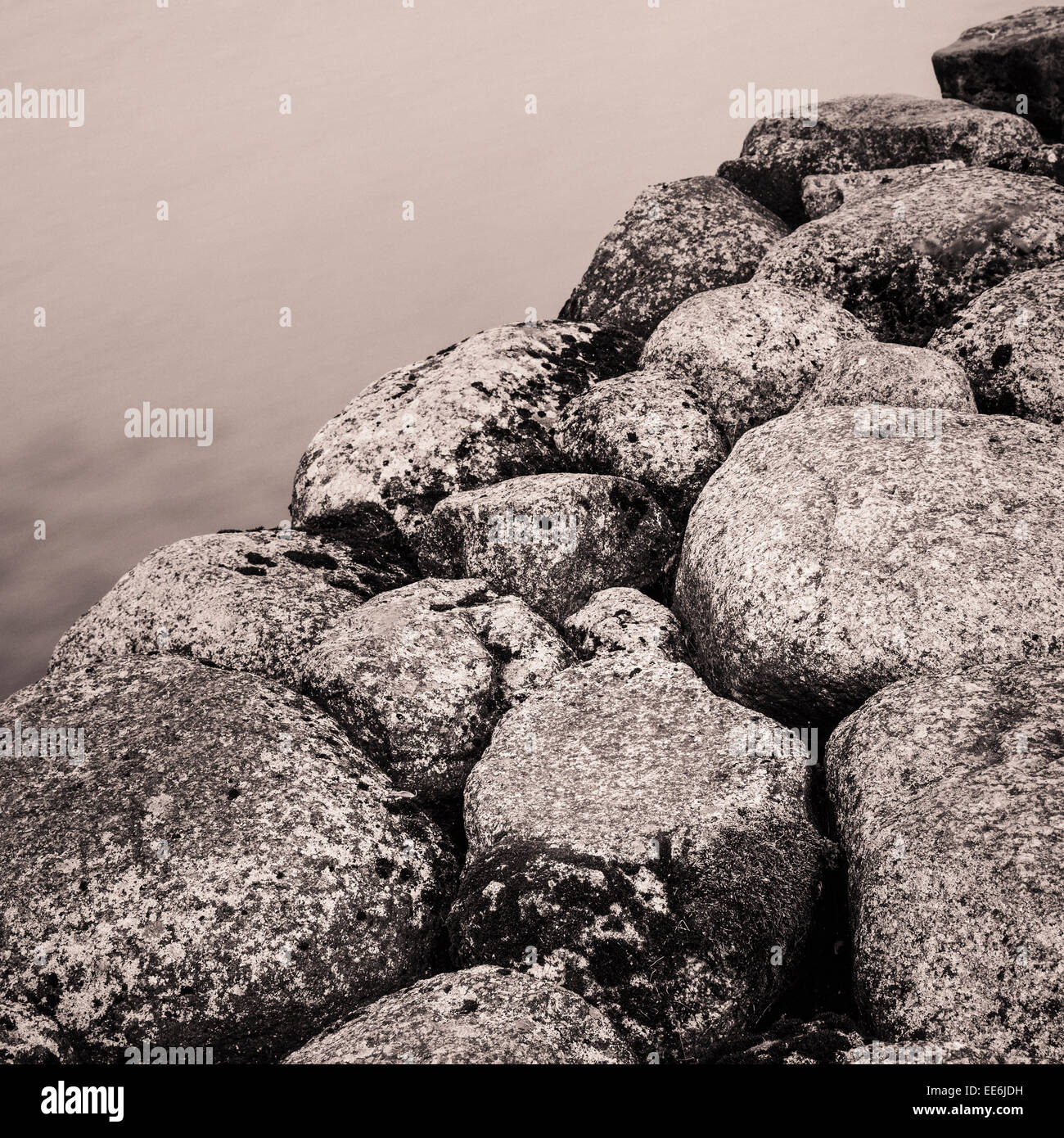 Ruhigen Art Szene mit langer Belichtungszeit von dunklen Felsen und stilles Wasser Stockfoto