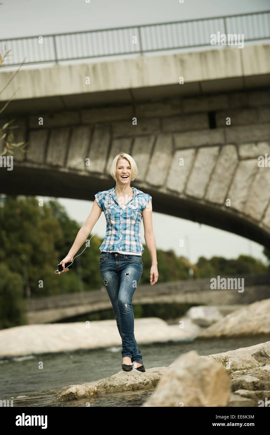 Junge Frau zu Fuß auf der Uferpromenade, München, Bayern, Deutschland Stockfoto