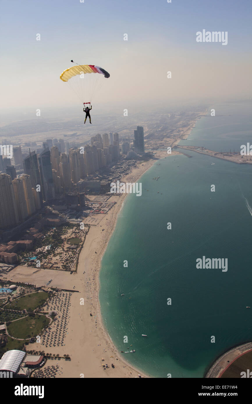 Fallschirmspringer unter Vordach fliegt über die Stadt Dubai Marina entlang der Uferlinie. Es ist eine perfekte Sicht über den sandigen Stränden. Stockfoto