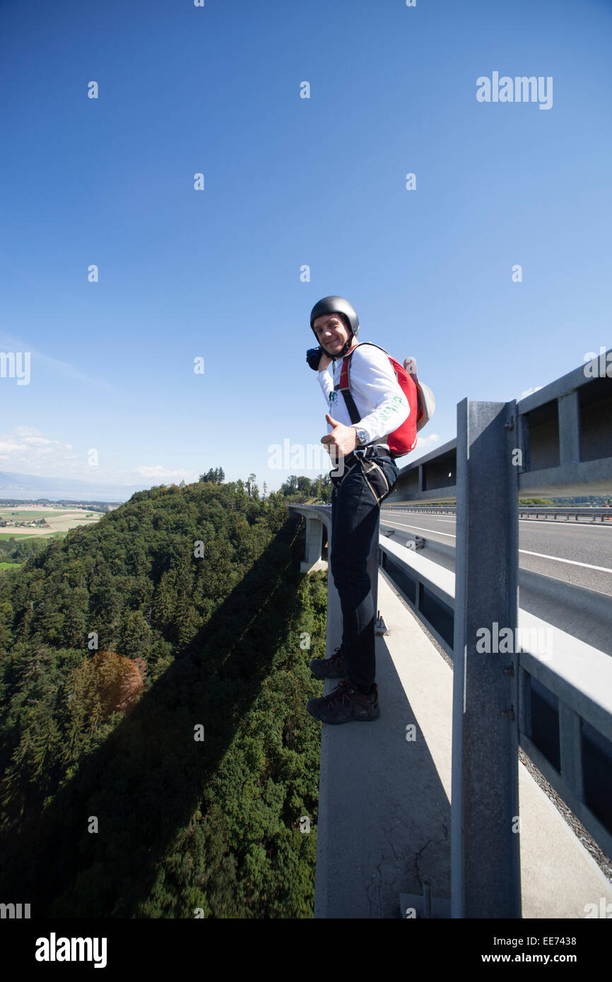 Dieser Mann wird von der Brücke springen. Es sieht aus wie er sehr aufgeregt ist, diese BASE-Jump zu tun und dabei er viel lächelt. Stockfoto