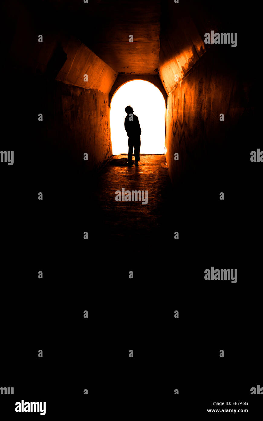 Person in langen Tunnel Gehweg mit weißem Licht am Ende Stockfoto