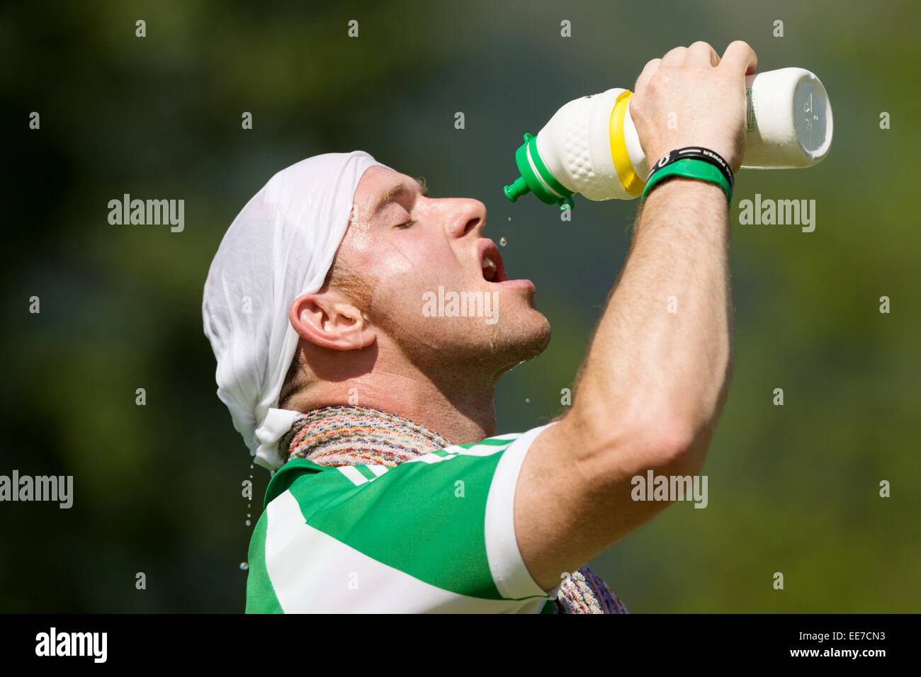 Beauly Spieler presst den letzten Tropfen aus seiner Flasche Wasser während der Hitze des Tages. Balliemore-Cup-Finale 2013 Beauly V Bute. Stockfoto