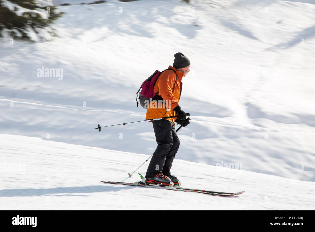 Skifahrer mit Rucksack Skifahren auf der Piste im Wintersportort in den Alpen Stockfoto