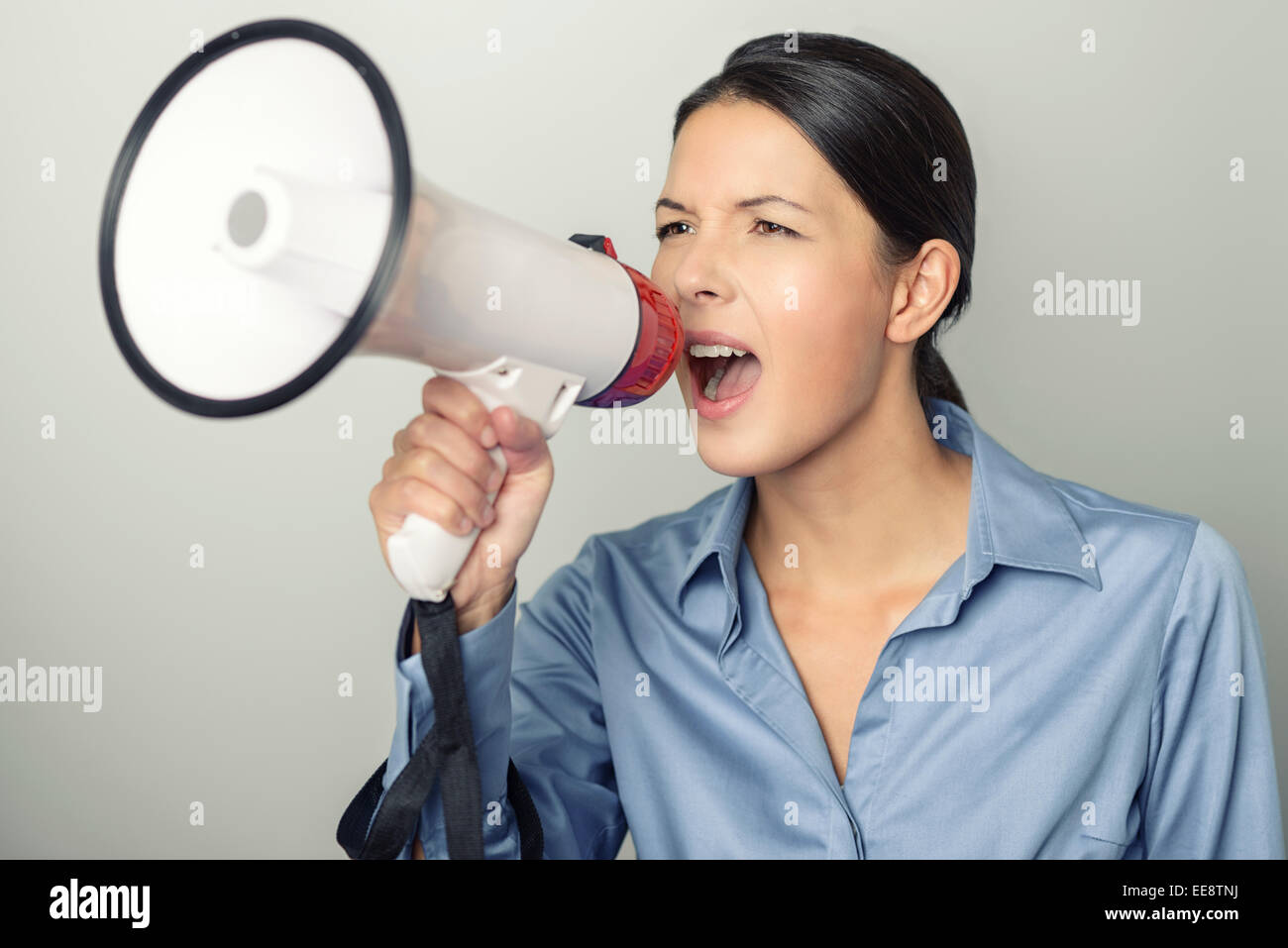 Frau spricht über ein Megaphon, da sie eine öffentliche Adresse macht beteiligt sich an einem Protest oder organisiert eine Rallye oder promotion Stockfoto