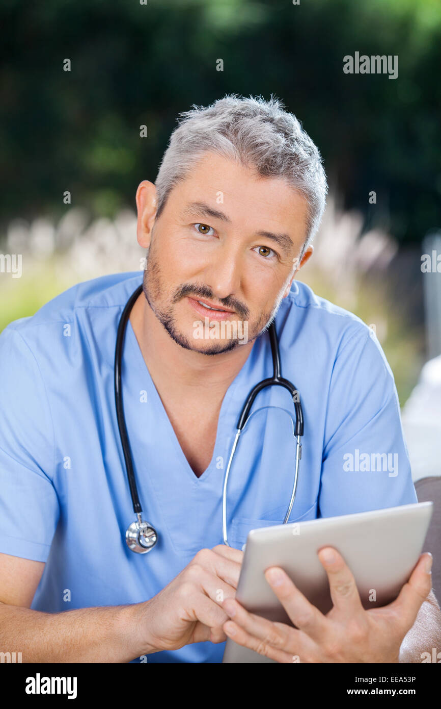 Männliche Krankenschwester mit digitalen Tablet am Pflegeheim Stockfoto