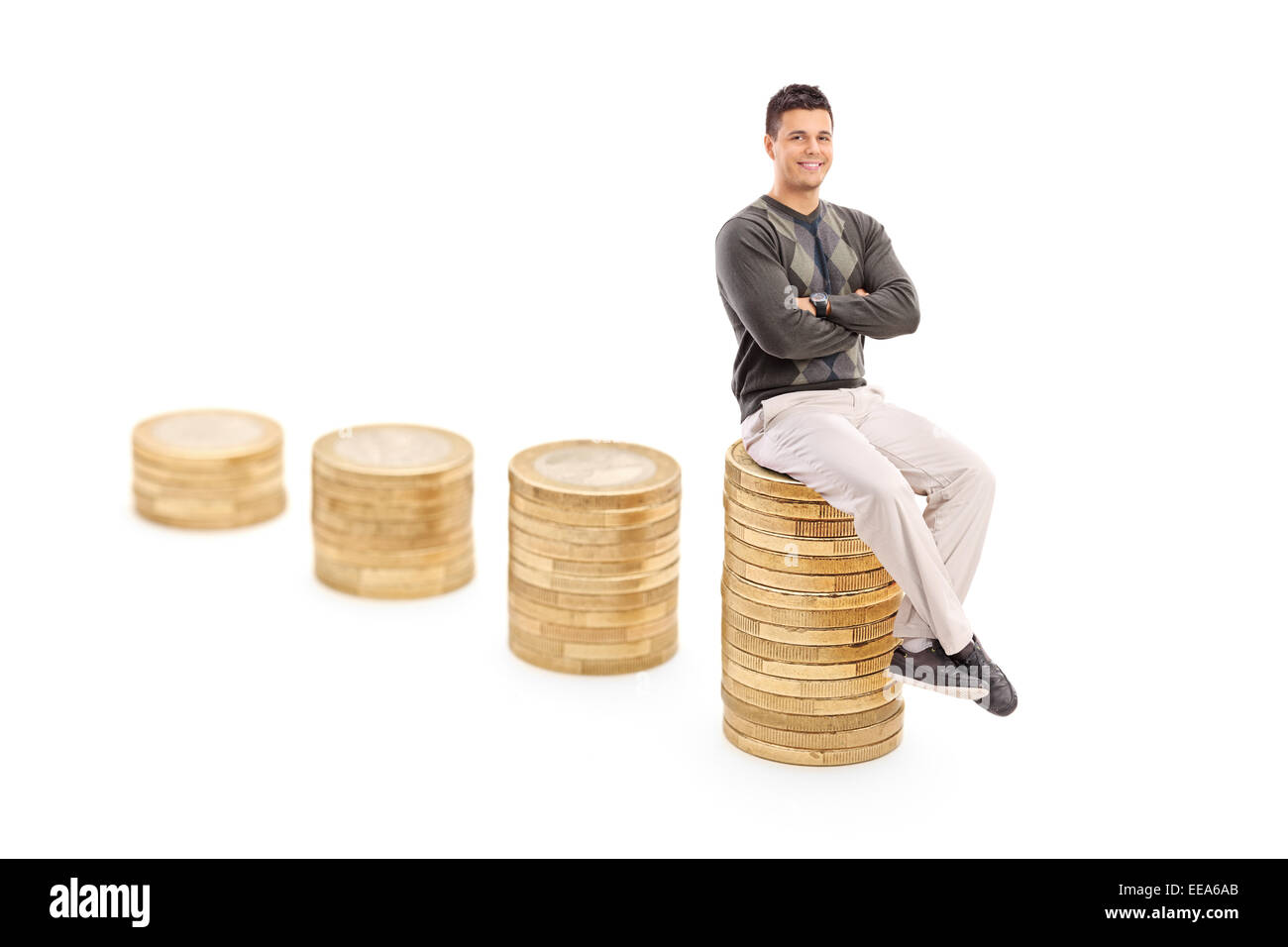 Legerer Mann sitzt auf einem Stapel von Münzen isoliert auf weißem Hintergrund Stockfoto