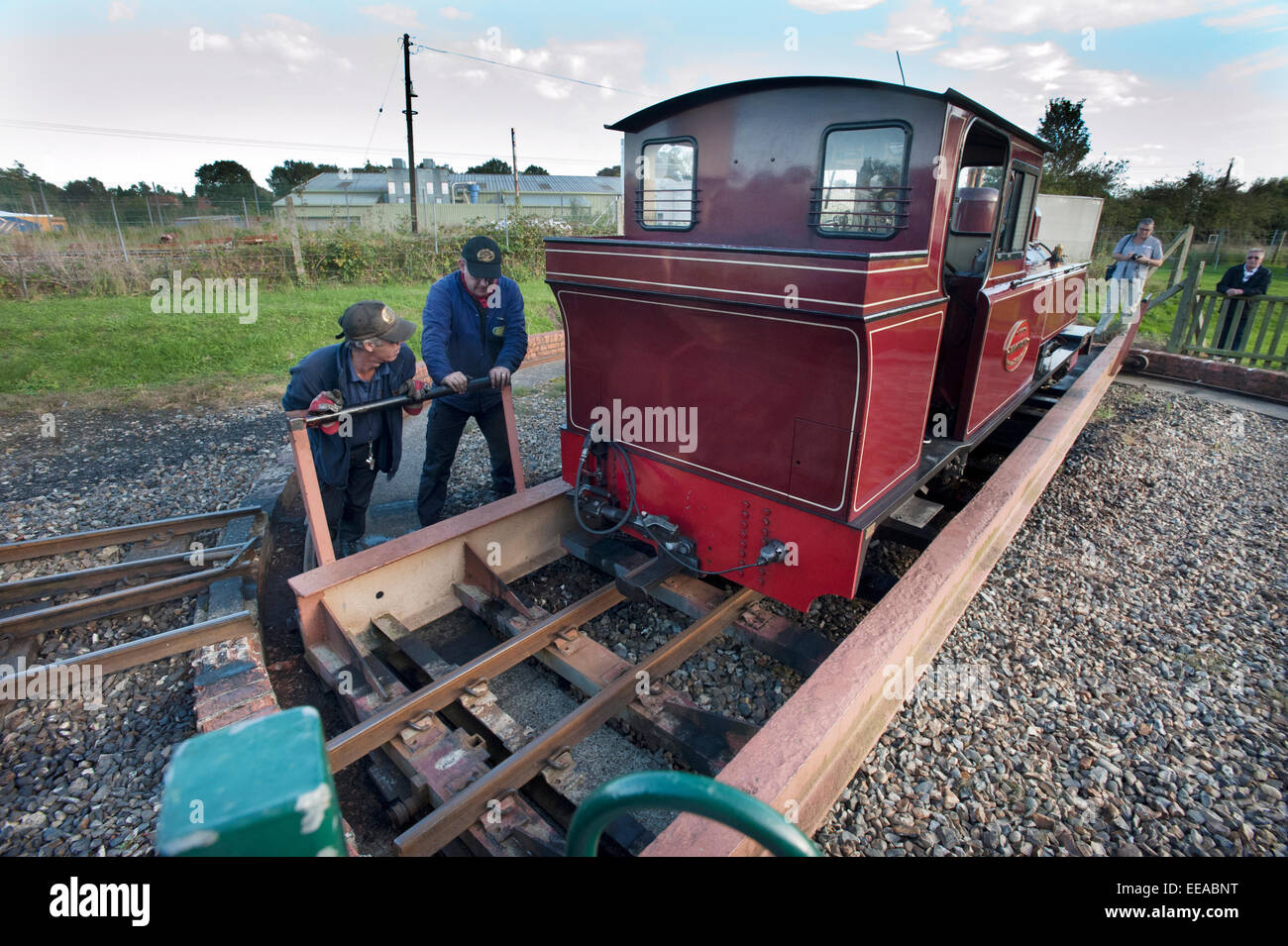 Fahrer und Feuerwehrmann verwenden die Drehscheibe am Wroxham Bahnhof Terminus zu ihren 15-Zoll-Schmalspur-Dampflokomotive "Mark Timothy" davor Runde seinen Zug auf die Bure Valley Railway Aylsham auf die 9 Meilen zwischen Aylsham und Wroxham, in der Nähe von Norwich, Norfolk wieder ausgeführt wird. Stockfoto