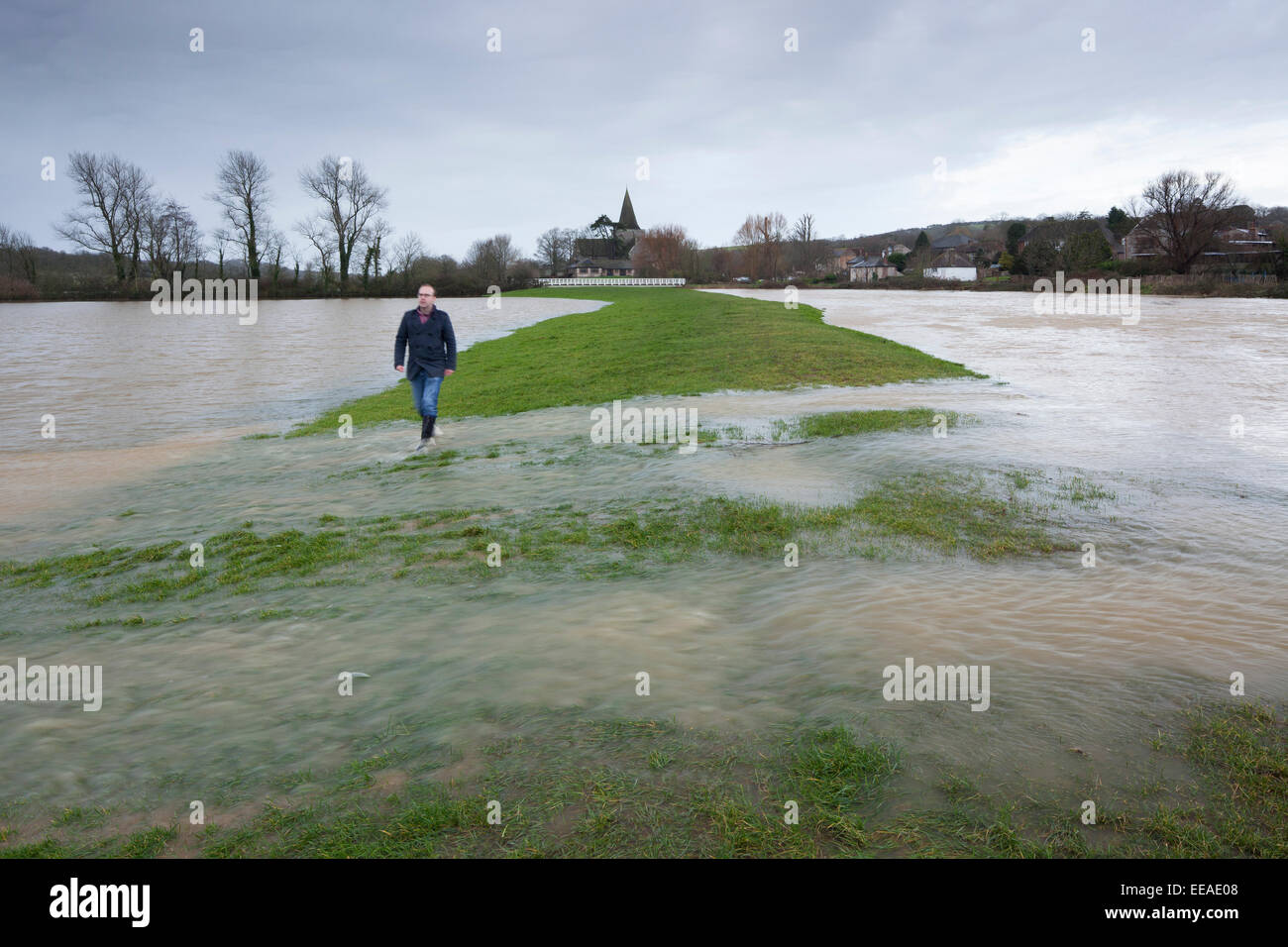 Ein Mann geht durch stark überschwemmten Feldern in Eastbourne, East Sussex, England. Stockfoto