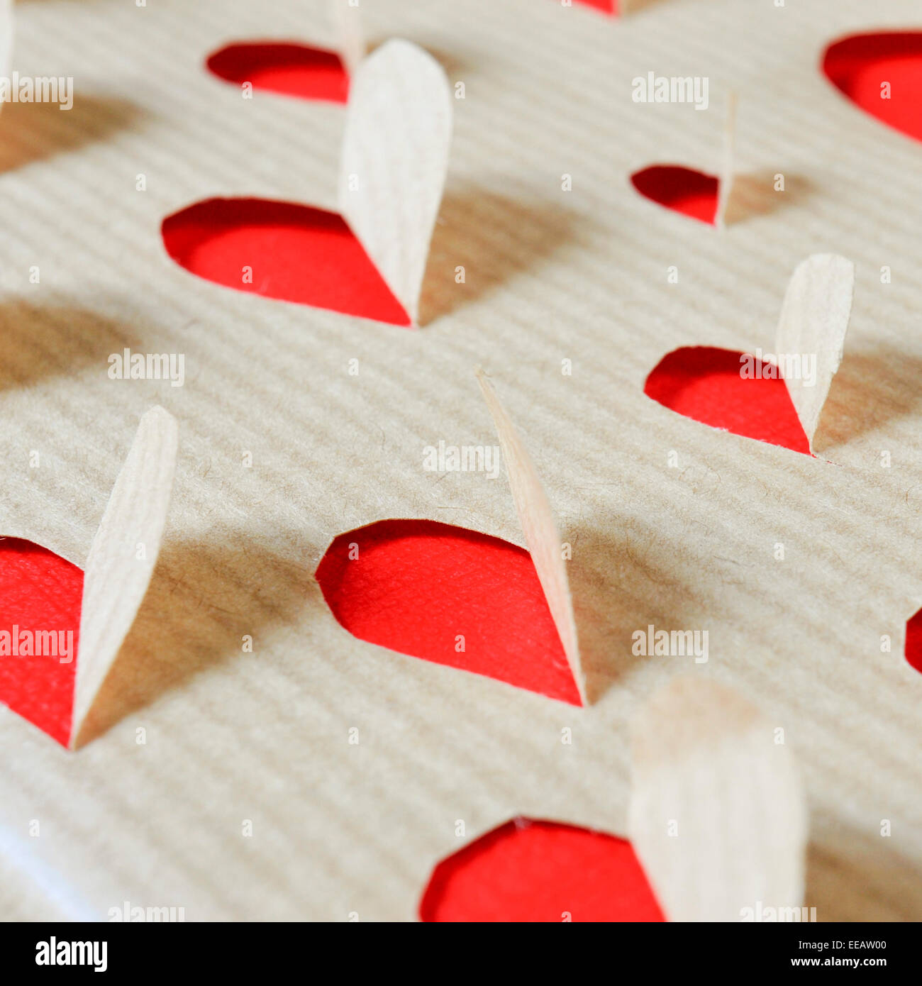 Löcher auf einem Kraftpapier bilden Herzen Stockfoto