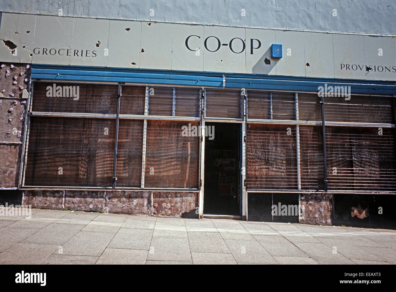 BELFAST, NORDIRLAND - MAI 1973. Mit Brettern vernagelt Shop Front mit Unternehmen wie gewohnt lackiert Zeichen während der Unruhen, Nordirland. Stockfoto