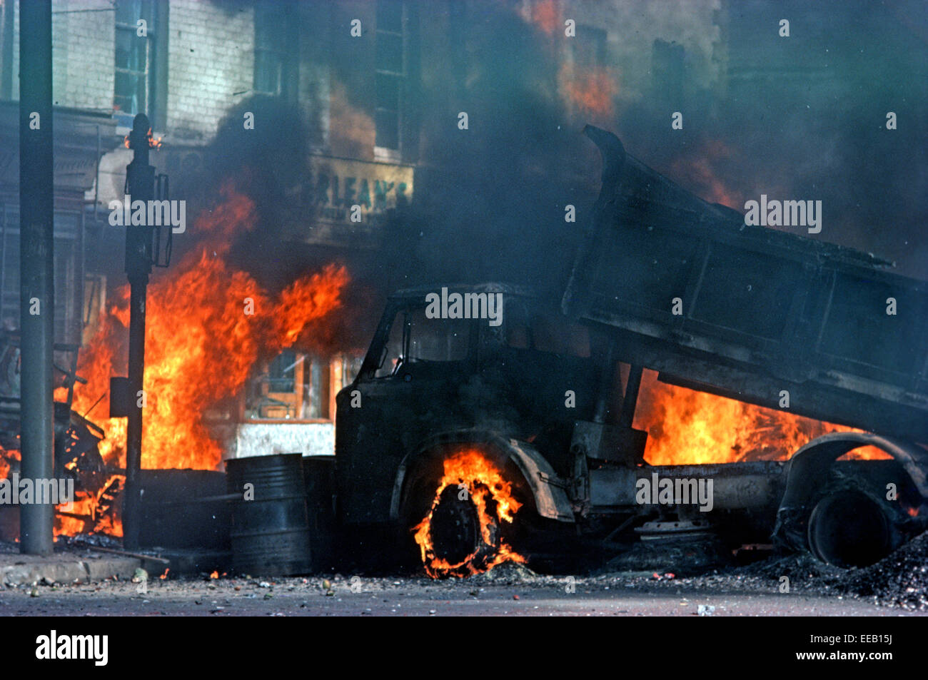 BELFAST, NORDIRLAND - AUGUST 1976. Brennen Sie entführten Fahrzeuge während der Unruhen auf der Falls Road, West Belfast während der Unruhen, Nordirland. Stockfoto