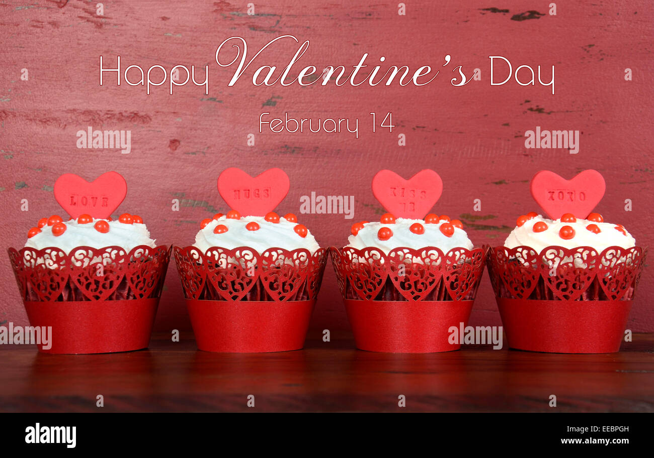 Happy Valentines Day Reihe red Velvet Cupcakes mit Liebesbotschaften und Beispieltext auf rotem Holz. Stockfoto