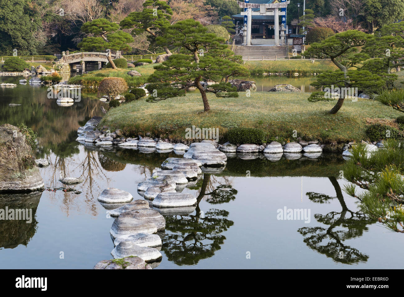 Kumamoto, Kyushu, Japan. Der Spaziergang Garten Suizen-Ji Joju-En, begonnen im Jahre 1632. Der Teich mit dem Izumi-Schrein im Hintergrund Stockfoto