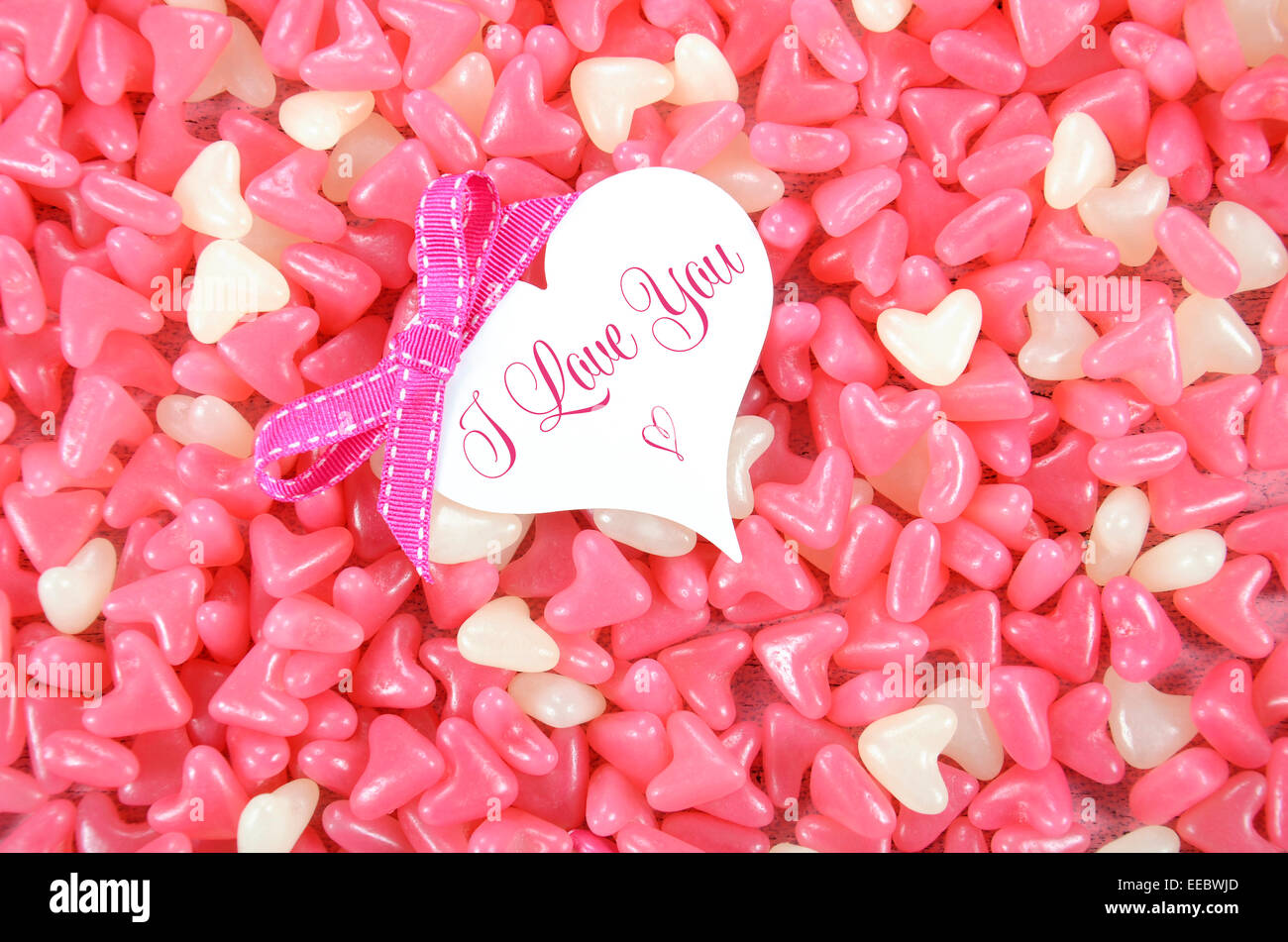 Valentinstag-Pink und weiß Herz Form Gelee Süßigkeiten Süßwaren auf rosa Holz Hintergrund mit Herz-Grußkarte Stockfoto