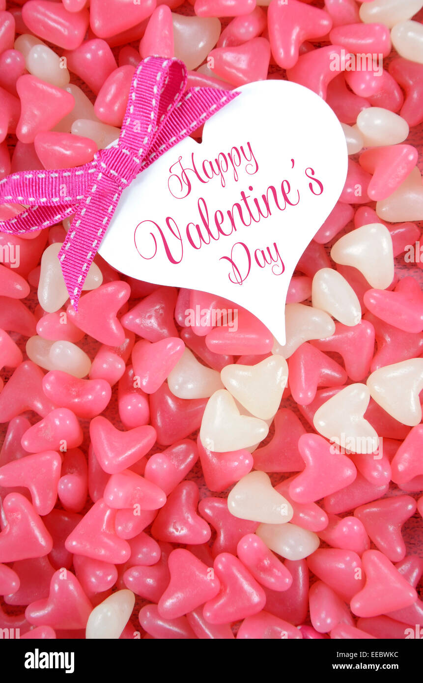 Valentinstag-Pink und weiß Herz Form Gelee Süßigkeiten Süßwaren auf rosa Holz Hintergrund mit Herz-Grußkarte Stockfoto