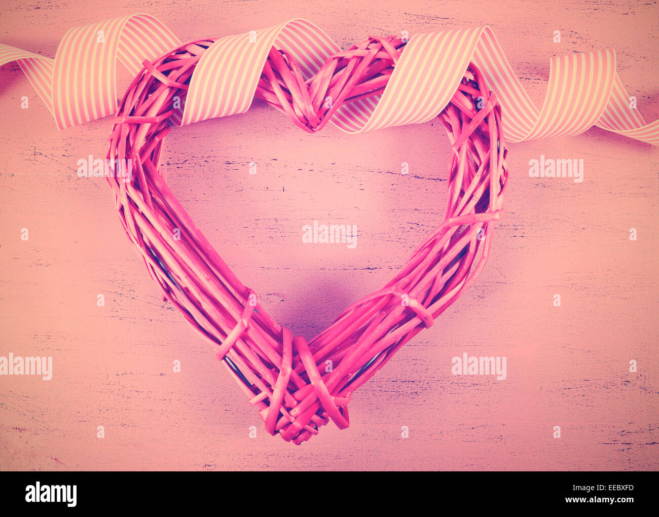 Retro Vintage Filter Happy Valentines Day Herz Form Zuckerrohr Kranz auf Pnk Holz Hintergrund. Stockfoto