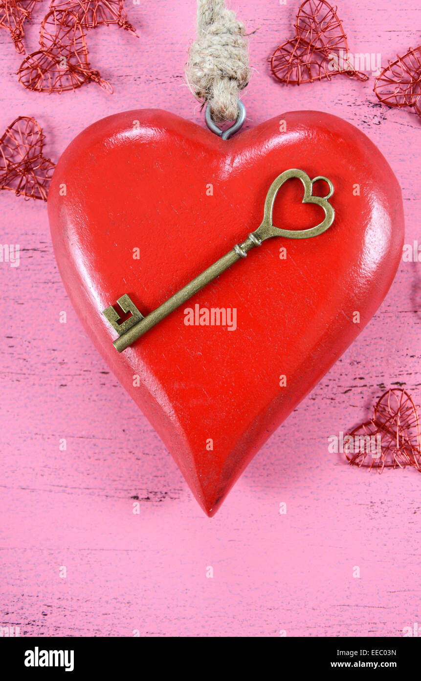 Glücklich Valentinstag Schlüssel zu meinem Herzen-Konzept mit großen hängenden Herzen auf shabby chic rosa Holz Hintergrund. Stockfoto
