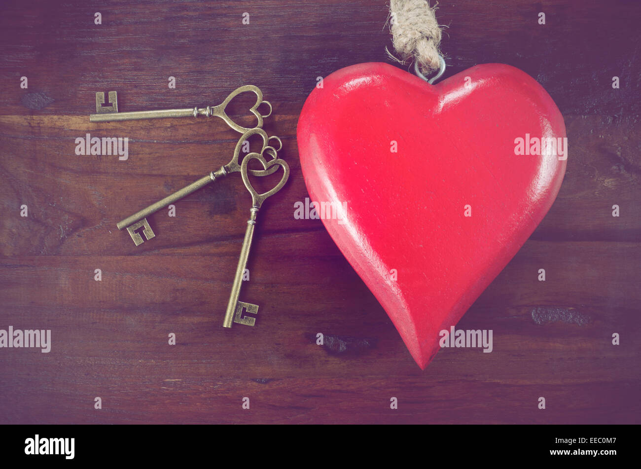 Retro-Vintage-Stil Happy Valentines Day Schlüssel zu meinem Herzen-Konzept mit großen hängenden Herzen auf dunklem Holz. Stockfoto