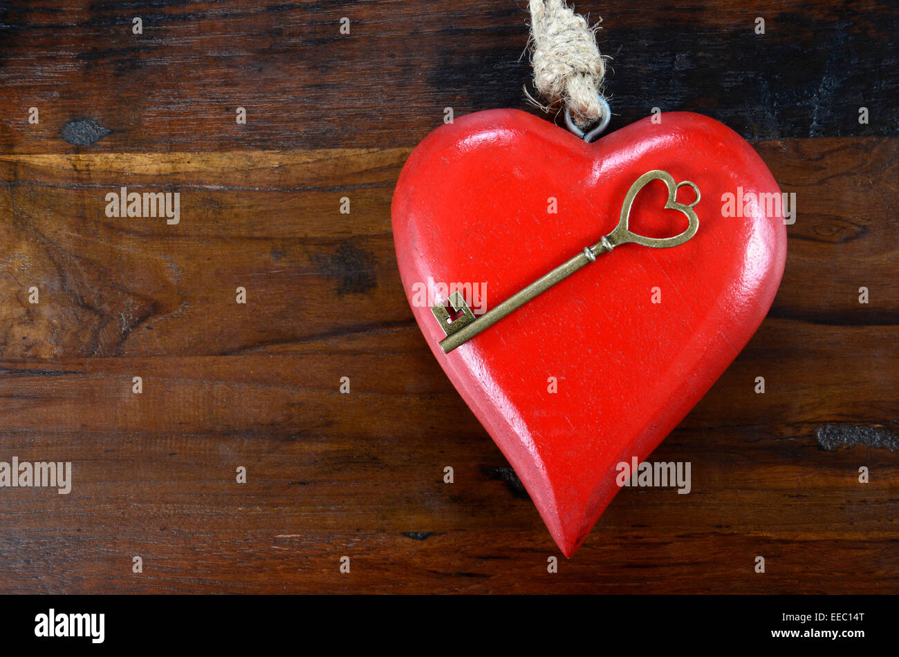 Glücklich Valentinstag Schlüssel zu meinem Herzen-Konzept mit großen hängenden Herzen auf dunklem Holz. Stockfoto