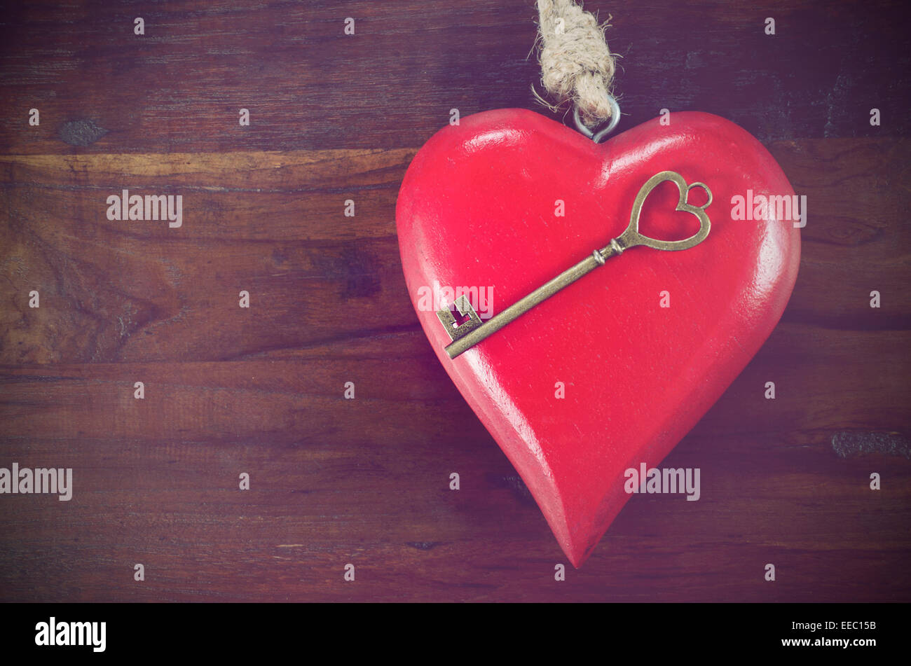 Retro-Vintage-Stil Happy Valentines Day Schlüssel zu meinem Herzen-Konzept mit großen hängenden Herzen auf dunklem Holz Stockfoto
