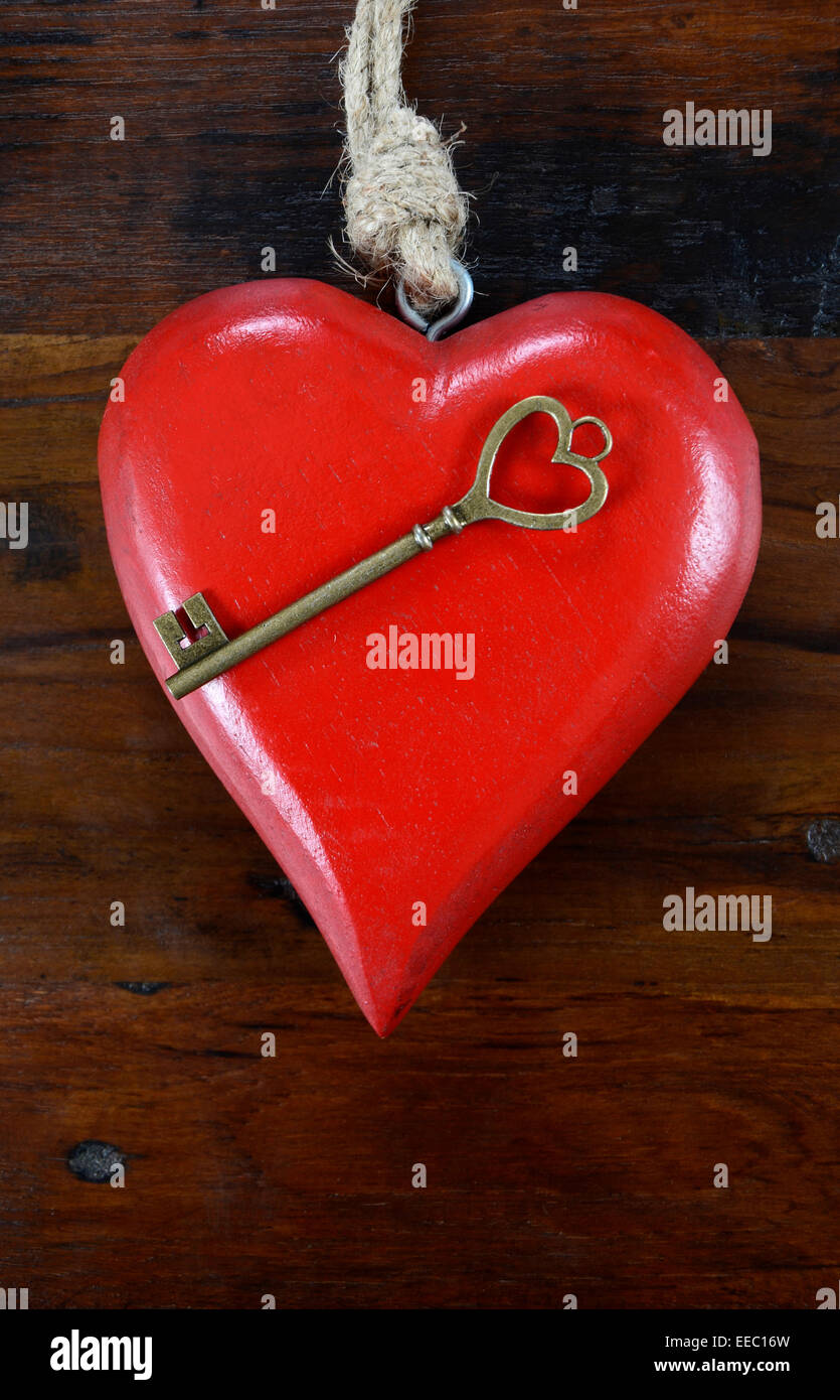 Glücklich Valentinstag Schlüssel zu meinem Herzen-Konzept mit großen hängenden Herzen auf dunklem Holz. Stockfoto