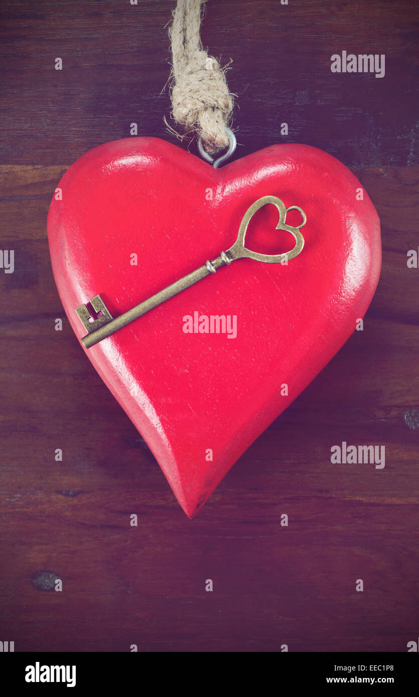 Retro-Vintage-Stil Happy Valentines Day Schlüssel zu meinem Herzen-Konzept mit großen hängenden Herzen auf dunklem Holz, vertikale. Stockfoto