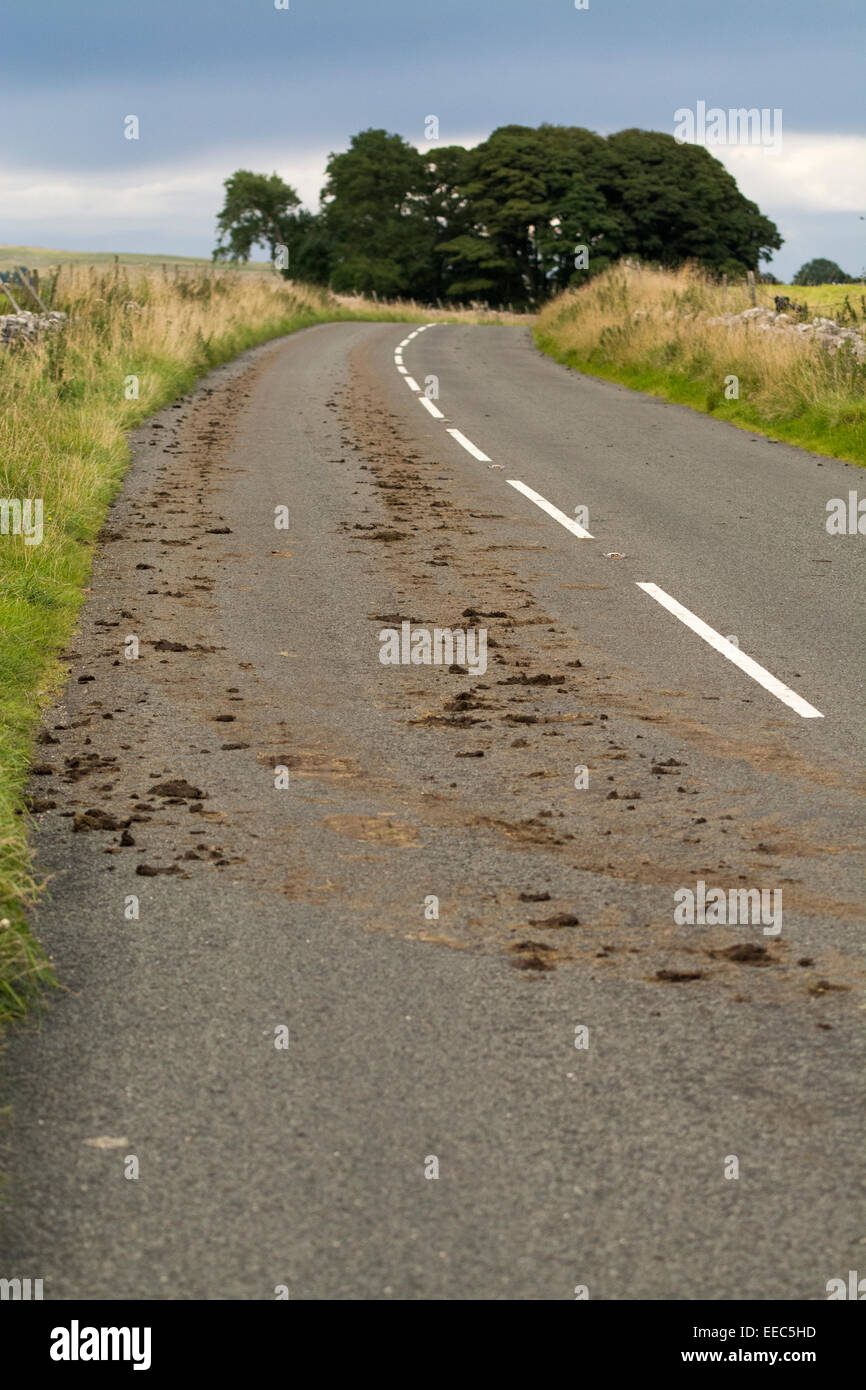 Schlamm auf der Hauptstraße, nach Traktor aus einem Feld mit Schlamm auf den Reifen. Cumbria. Stockfoto