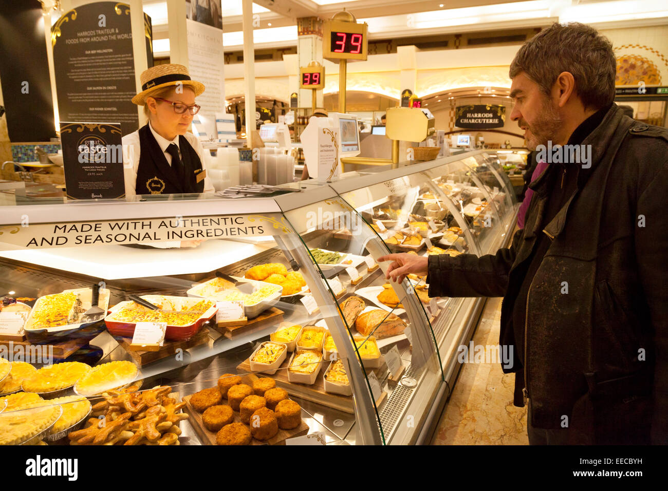 Ein Kunde, dienend in der Wurst-Halle, Harrods Kaufhaus, Kinightsbridge, London UK Stockfoto