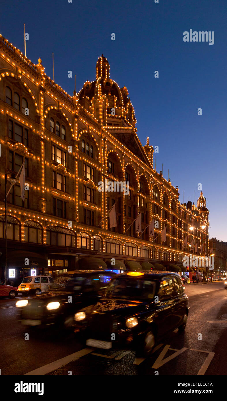 Das Kaufhaus Harrods, Knightsbridge, London in der Nacht mit einem London-Taxi; London-UK Stockfoto
