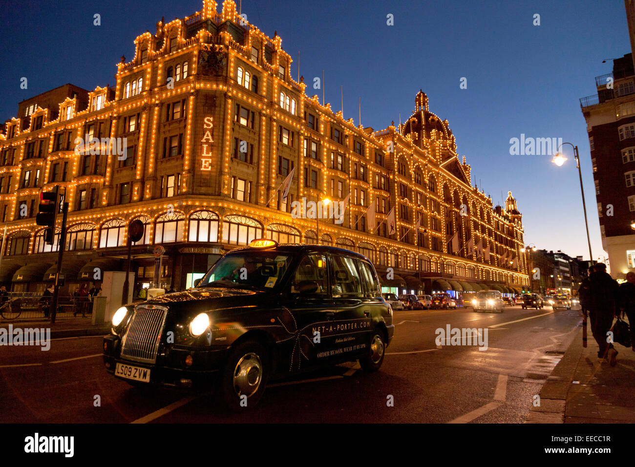 Das Kaufhaus Harrods, Knightsbridge, London in der Nacht mit einem London-Taxi; London-UK Stockfoto