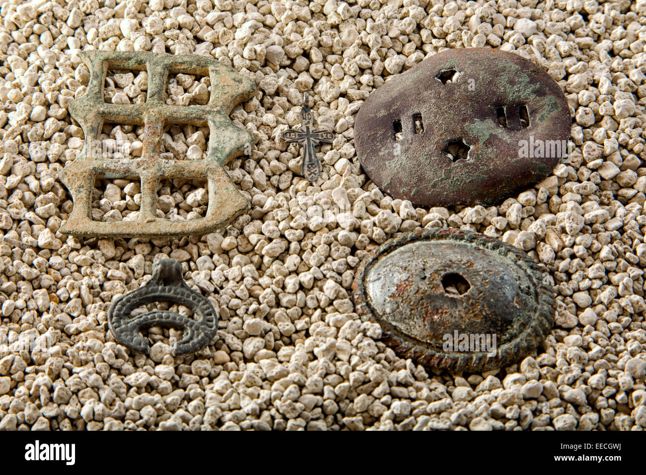 Artefakte auf dem White River Sand. Schmuck-Ausritte, heidnischer Talisman und das christliche Kreuz. Stockfoto