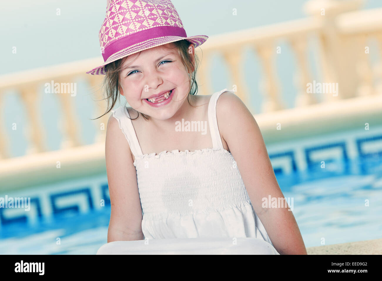 Aufnahme eines jungen Mädchens am Pool sitzen Stockfoto